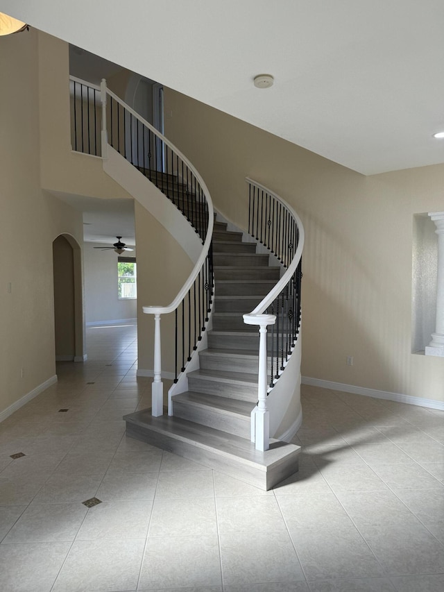 stairs with tile patterned floors and ceiling fan