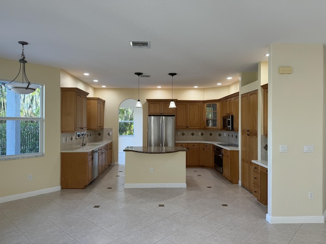 kitchen with appliances with stainless steel finishes, pendant lighting, a healthy amount of sunlight, and sink