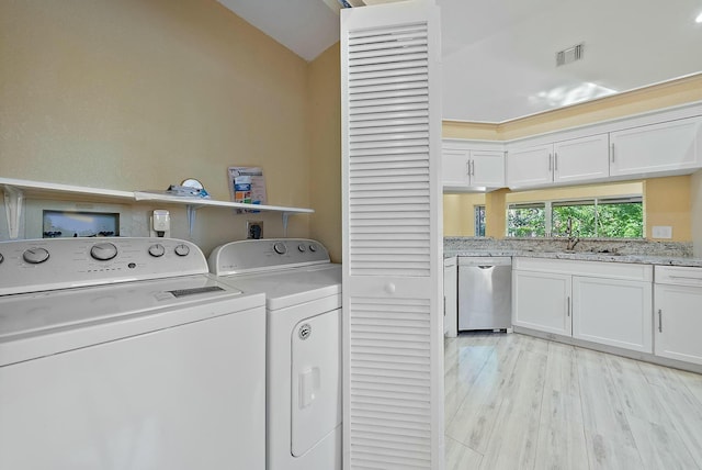 laundry room featuring separate washer and dryer, sink, and light hardwood / wood-style flooring