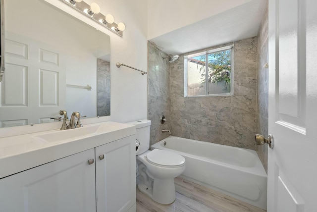 full bathroom featuring vanity, wood-type flooring, tiled shower / bath combo, and toilet