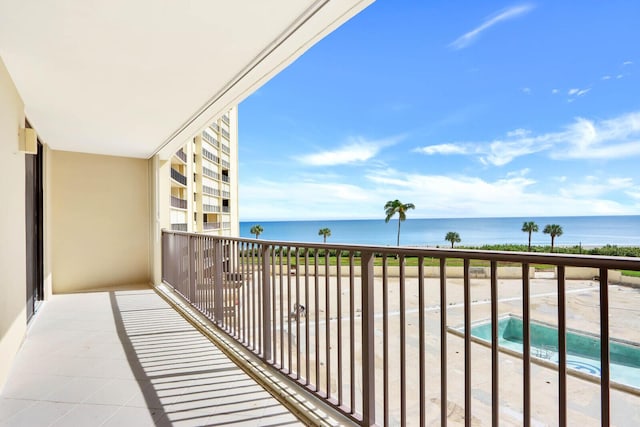 balcony with a water view and a hot tub