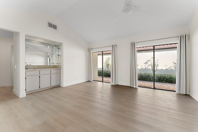 unfurnished living room featuring light wood-type flooring, ceiling fan, lofted ceiling, and sink