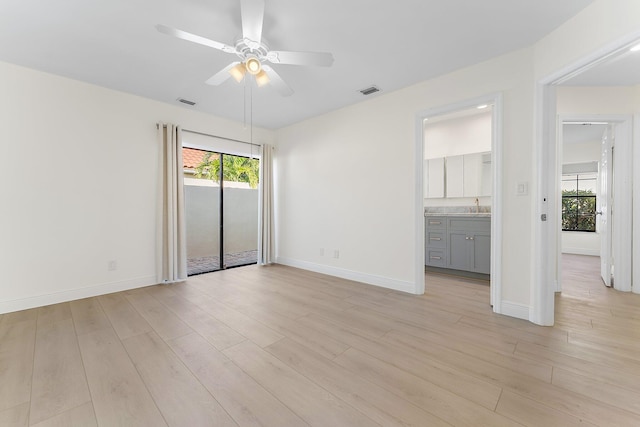 empty room featuring ceiling fan, light wood-type flooring, and sink