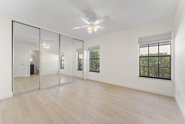 unfurnished bedroom with light wood-type flooring, multiple windows, and ceiling fan