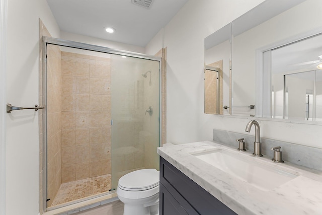 bathroom with hardwood / wood-style floors, vanity, toilet, and a shower with door