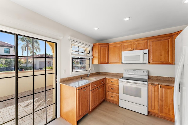 kitchen with white appliances, light hardwood / wood-style floors, and sink