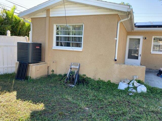 view of side of home featuring solar panels, a yard, and central AC