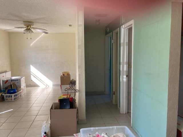 hallway featuring light tile patterned floors and a textured ceiling