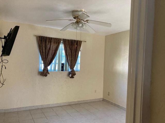 tiled empty room featuring ceiling fan