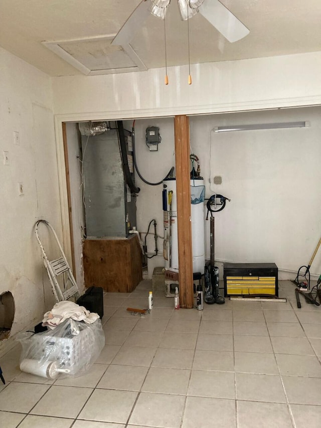 basement featuring ceiling fan, tile patterned flooring, and gas water heater