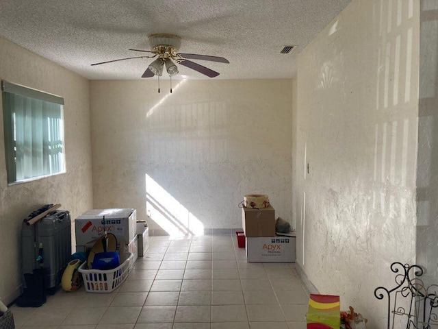 unfurnished room with light tile patterned floors, a textured ceiling, and ceiling fan