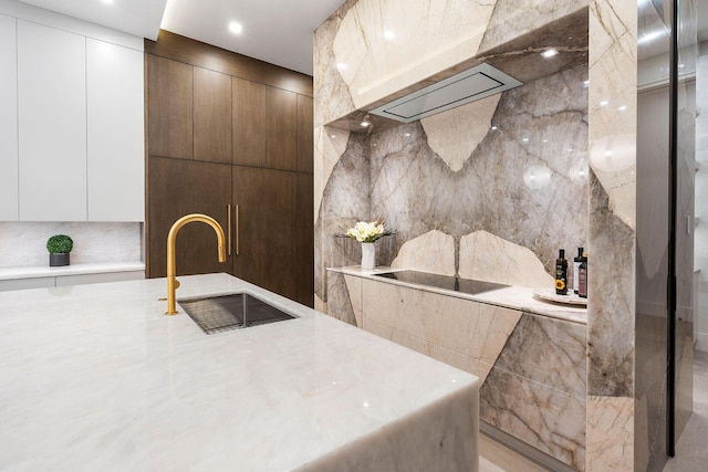 kitchen featuring white cabinetry, sink, and tile walls