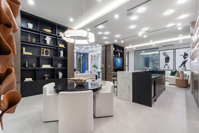 living room featuring built in shelves, sink, and light tile patterned flooring