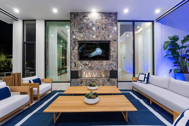 living room featuring a large fireplace, tile patterned floors, and expansive windows