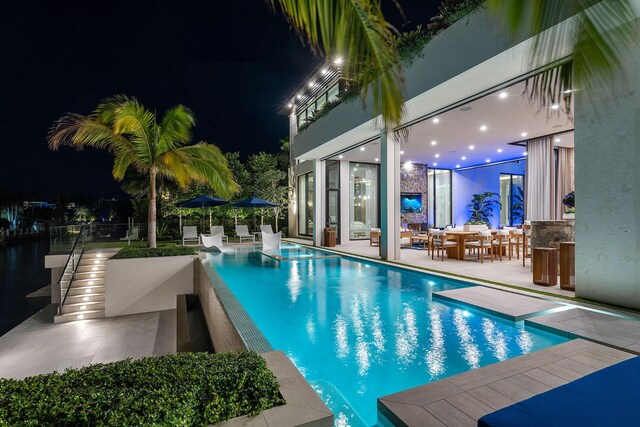 pool at night with a patio area