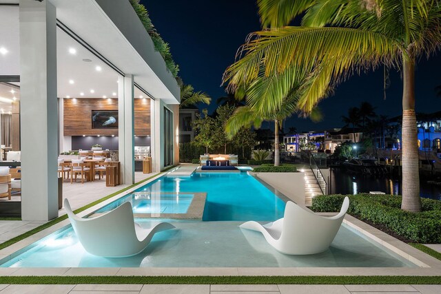 pool at night with an in ground hot tub