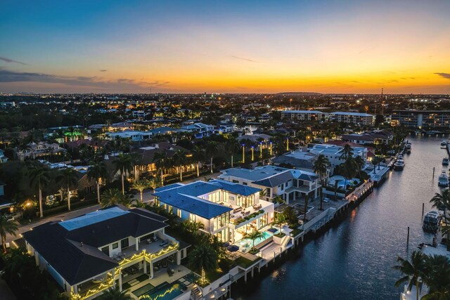 aerial view at dusk featuring a water view