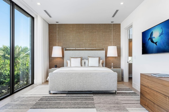 bedroom featuring multiple windows and light wood-type flooring