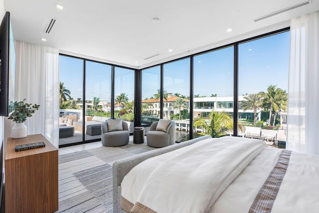 bedroom featuring multiple windows, a wall of windows, and access to outside