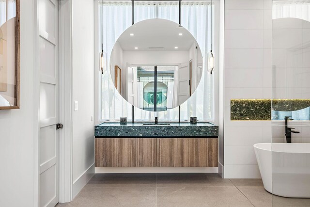 bathroom with tile patterned floors, vanity, shower with separate bathtub, and tile walls