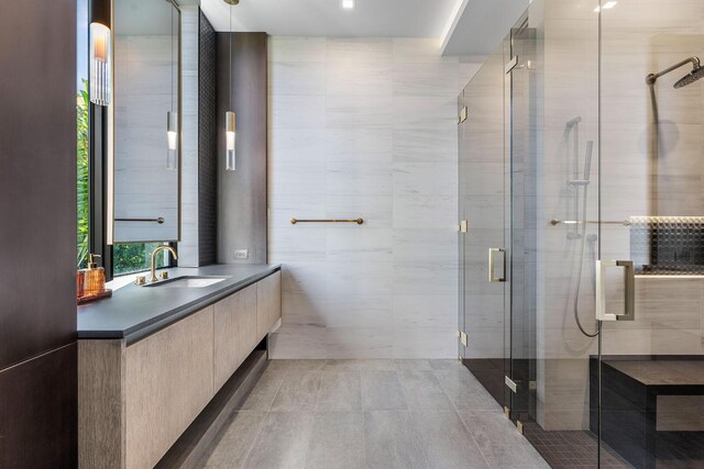 bathroom featuring vanity, tile walls, and a shower with shower door