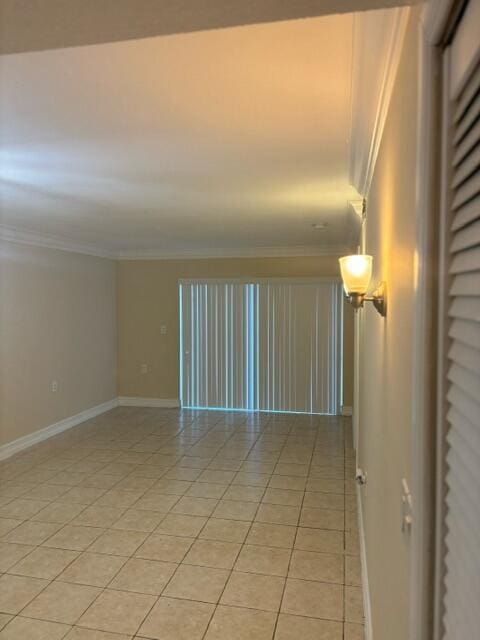 spare room featuring light tile patterned flooring and ornamental molding