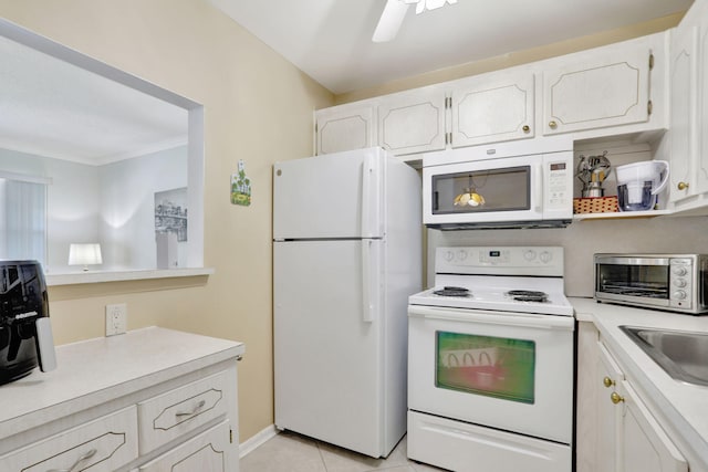 kitchen with white appliances, sink, ceiling fan, light tile patterned floors, and white cabinetry