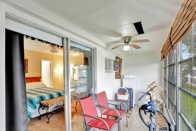 sunroom featuring a wall unit AC and ceiling fan