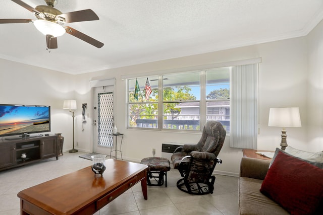 living room with ceiling fan, light tile patterned flooring, a textured ceiling, and ornamental molding