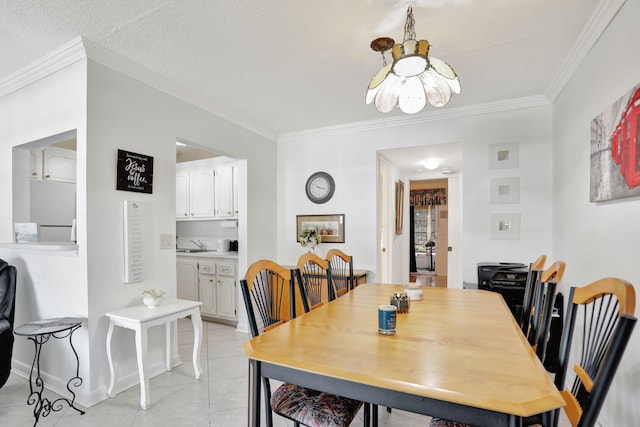 tiled dining area featuring sink, ornamental molding, and a textured ceiling