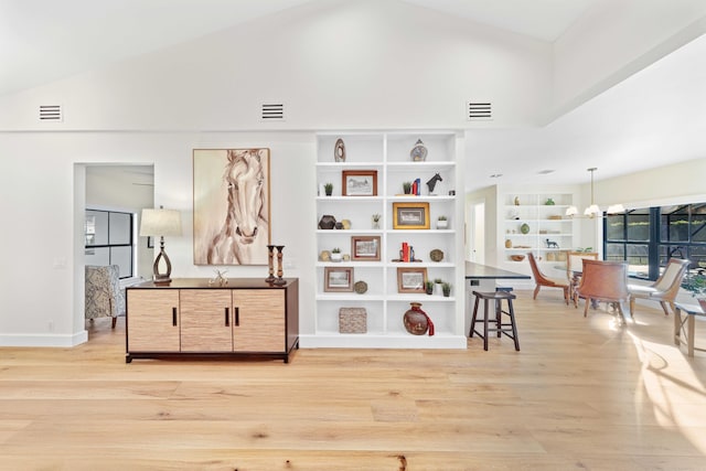 interior space with light hardwood / wood-style floors and high vaulted ceiling