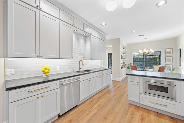 kitchen featuring dishwasher, pendant lighting, tasteful backsplash, and sink