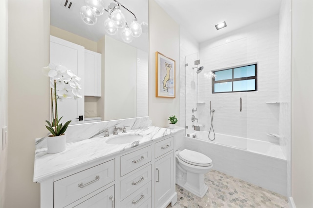 full bathroom featuring vanity, tiled shower / bath combo, and toilet