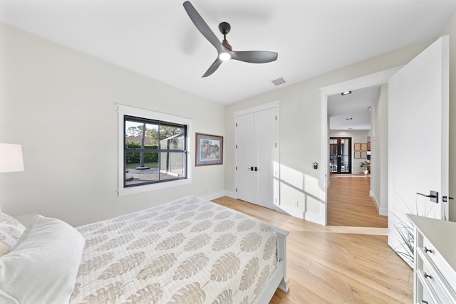 bedroom featuring ceiling fan, light wood-type flooring, and a closet