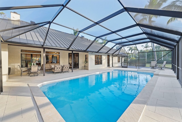 view of swimming pool with glass enclosure, a patio area, and an outdoor hangout area