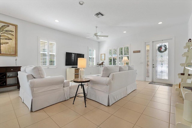 living room with light tile patterned floors, plenty of natural light, and ceiling fan