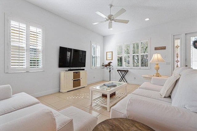 living room featuring ceiling fan, a textured ceiling, a wealth of natural light, and light tile patterned flooring