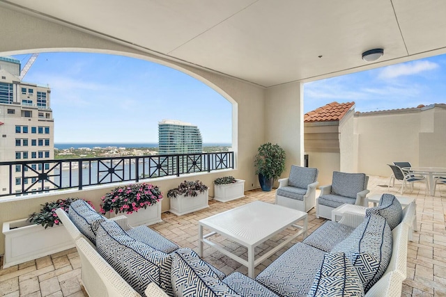 balcony featuring outdoor lounge area, a water view, and a patio area