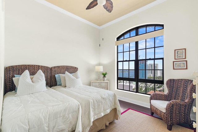 bedroom featuring multiple windows, ceiling fan, crown molding, and hardwood / wood-style flooring