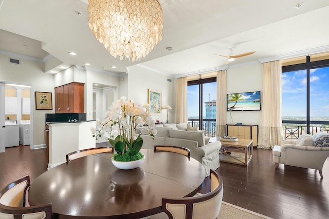 dining room featuring ceiling fan with notable chandelier, dark hardwood / wood-style flooring, separate washer and dryer, and ornamental molding