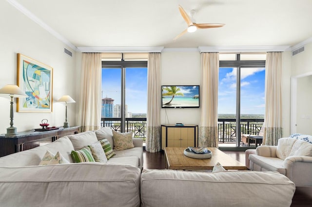 living room featuring ceiling fan, hardwood / wood-style floors, expansive windows, and ornamental molding