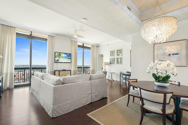 living room featuring ceiling fan with notable chandelier, dark hardwood / wood-style flooring, a wall of windows, and ornamental molding