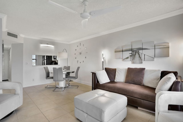 living room with a textured ceiling, ceiling fan, light tile patterned flooring, and crown molding