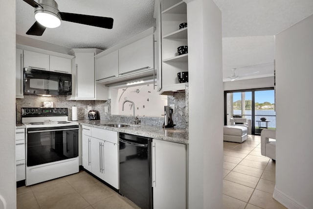 kitchen with tasteful backsplash, sink, black appliances, a water view, and white cabinetry