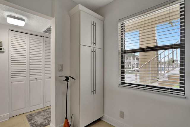 interior space with multiple windows, a closet, and a textured ceiling