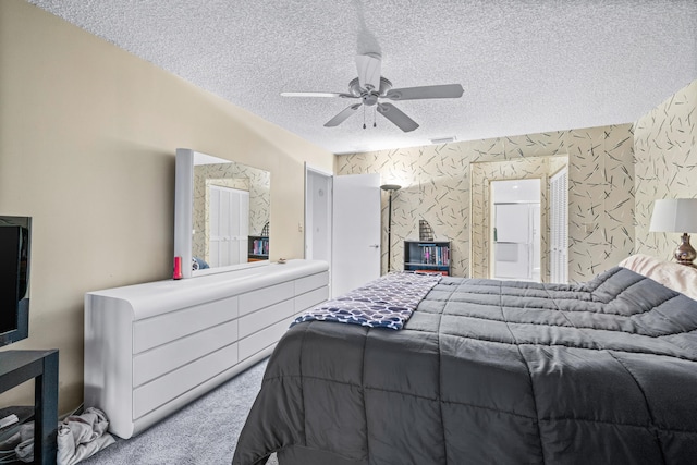 bedroom featuring ceiling fan, a textured ceiling, and light carpet