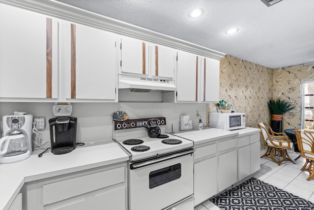 kitchen featuring a textured ceiling, white cabinets, light tile patterned flooring, and white appliances