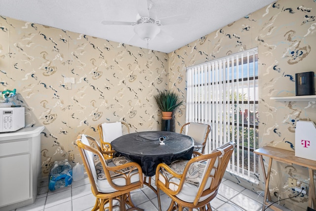 dining room with ceiling fan, light tile patterned flooring, and a textured ceiling