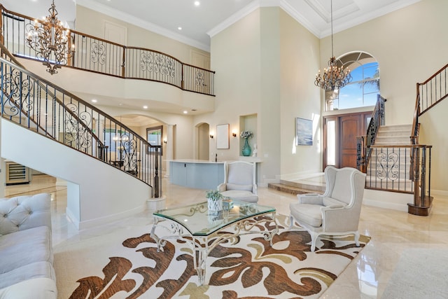 entrance foyer featuring a towering ceiling, ornamental molding, and a chandelier