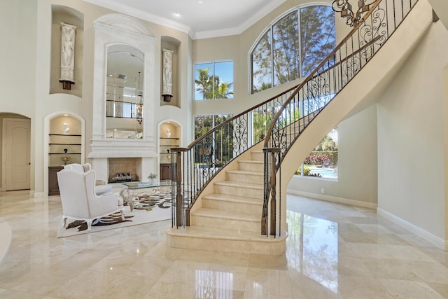 interior space featuring built in shelves, a towering ceiling, and crown molding